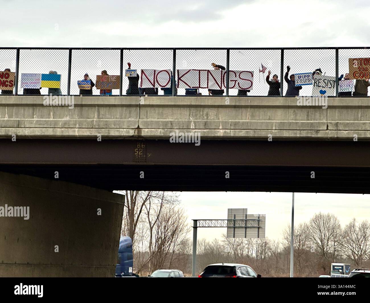 March 4, 2025. Protesters hold sings on a highway overpass at the No KIngs afternoon commute demonstration, Longmeadow, Massachusetts, United States, - Smartphone Captured Stock Image