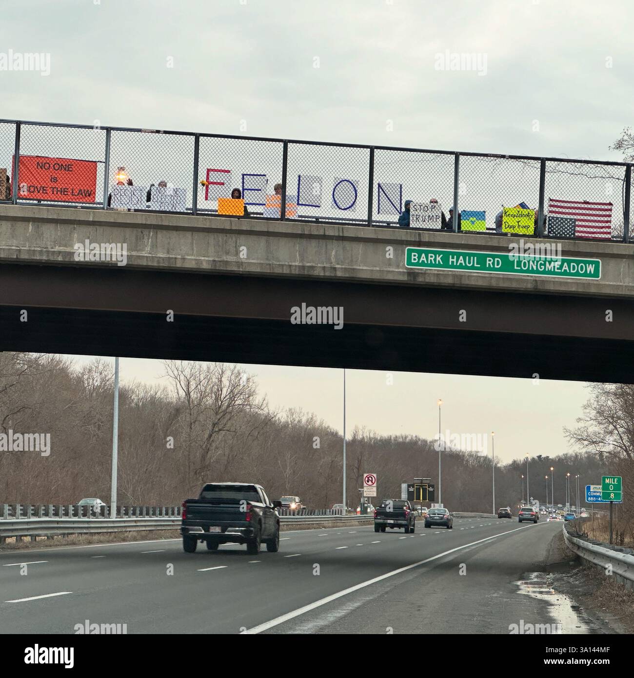 March 4, 2025. Protesters hold sings on a highway overpass at the No KIngs afternoon commute demonstration, Longmeadow, Massachusetts, United States - Smartphone Captured Stock Image