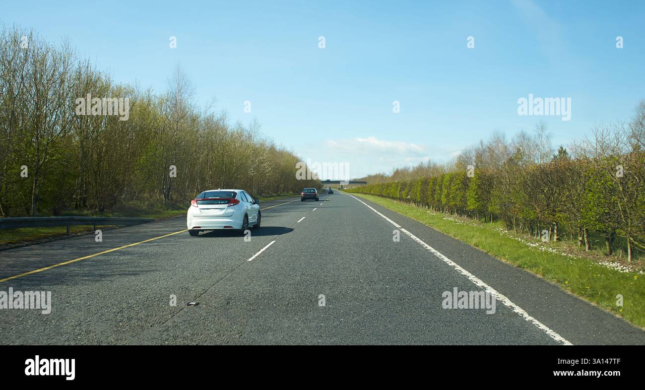 Rear view of cars driving on motorway, Ireland. Road with metal safety ...