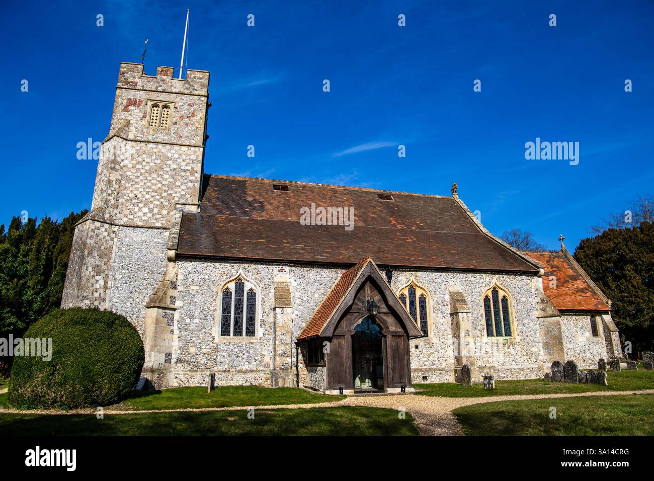 Historic stone church with a tall bell tower under a clear blue sky ...