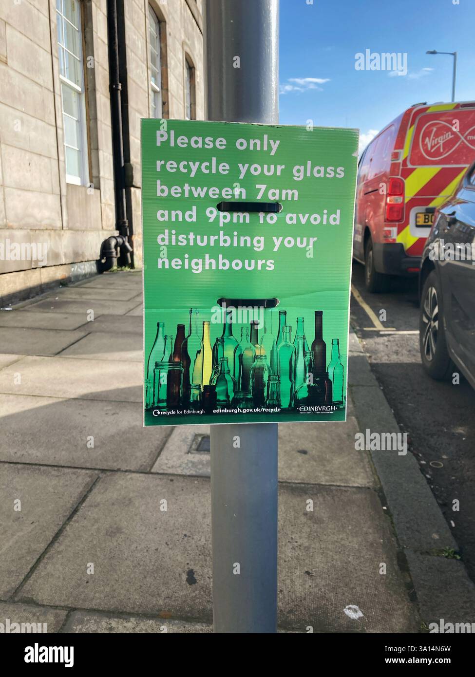 Please only recycle your glass between 7am and 9pm to avoid disturbing your neighbours sign on lamppost Stock Photo