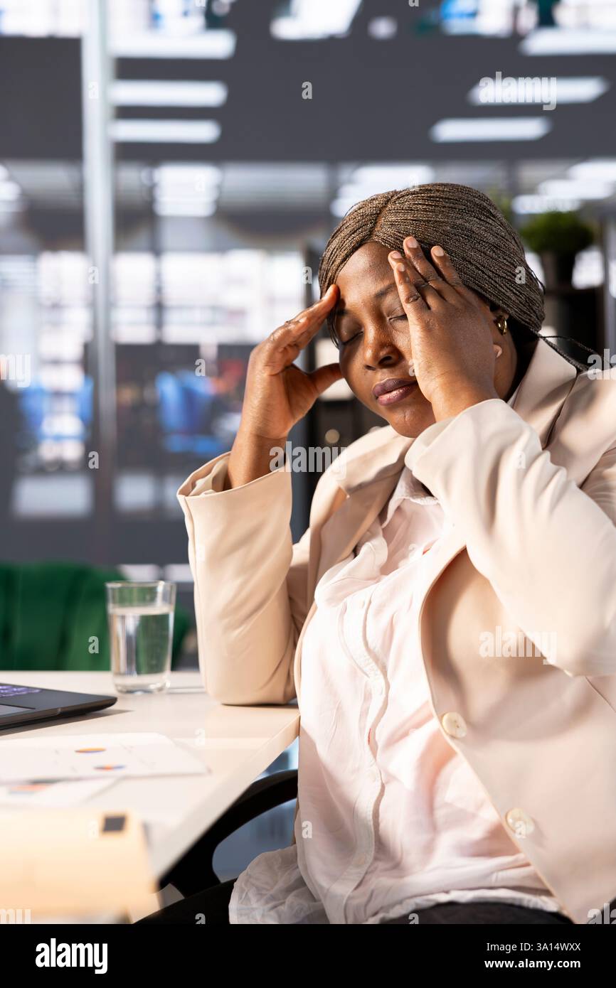 Aching CEO suffering migraine at work while using laptop to identify ...