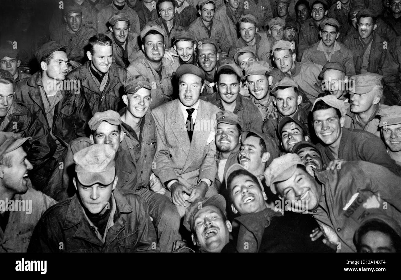 Bob Hope, radio and screen star, sitting with men of X Corps, as members of his troupe entertain, Wonsan, Korea, U.S. Army Signal Corps, October 26, 1950 Stock Photo