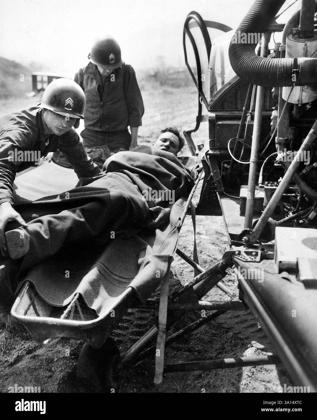 Wounded American being lifted onto helicopter at 21st Infantry Regiment collecting station at Painmal, Korea, one mile south of the 38th Parallel, for evacuation to base hospital, U.S. Army Signal Corps, April 3, 1951 Stock Photo