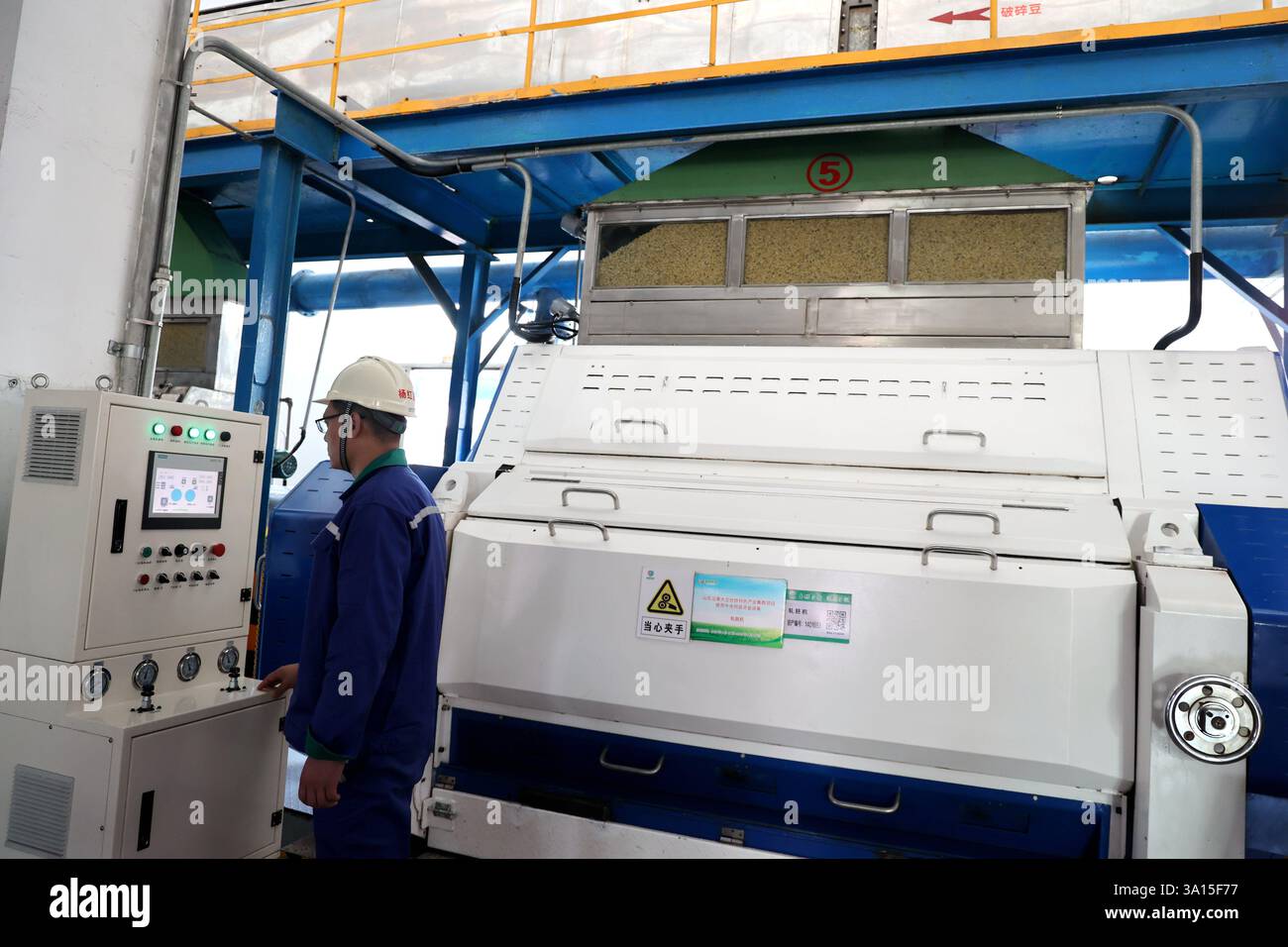 BINZHOU, CHINA - MARCH 6, 2025 - A worker operates machinery and ...