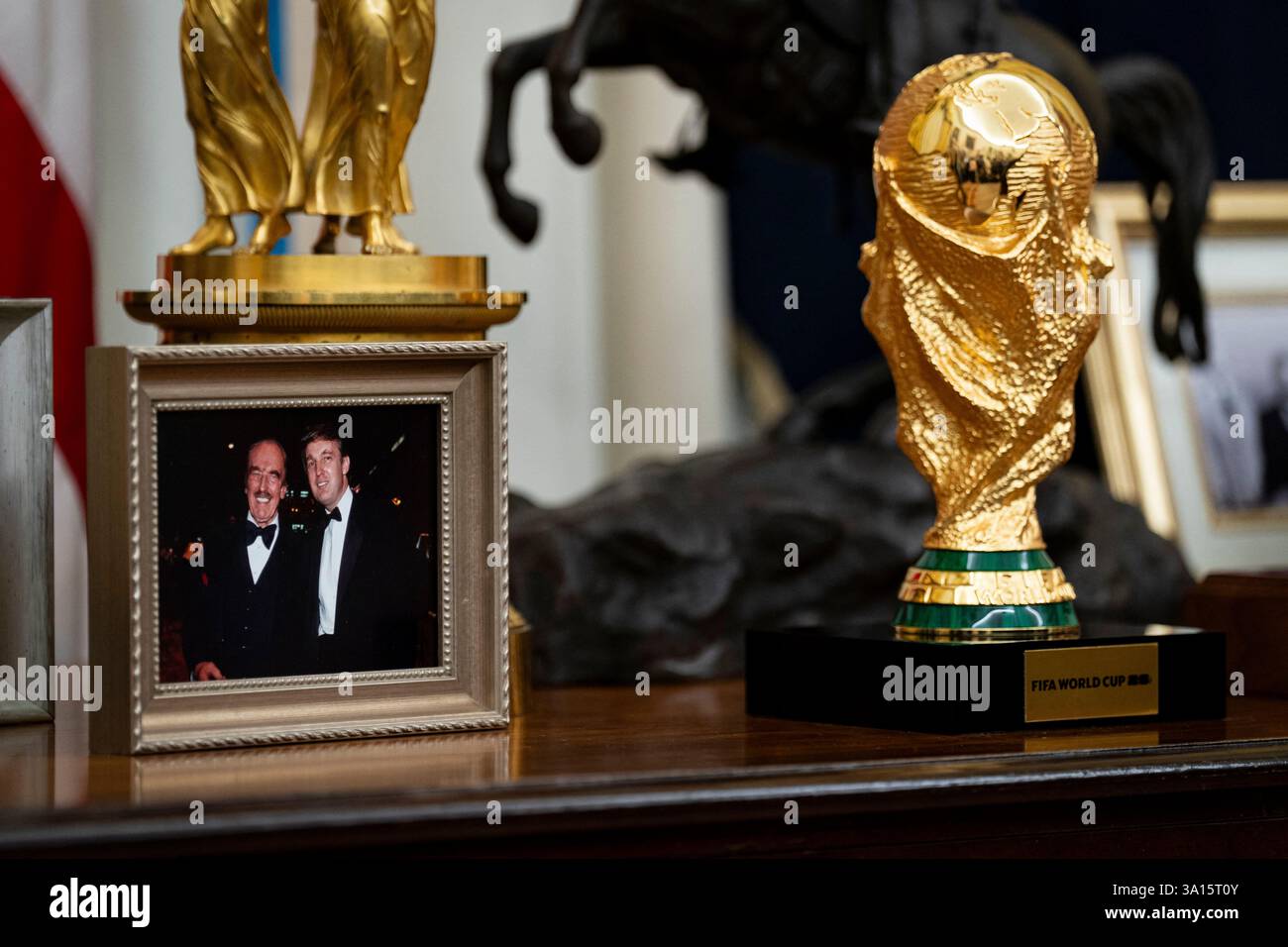A photograph of US President Donald Trump and his father, Fred Trump, and the FIFA World Cup, on a table behind Trump's desk in the Oval Office of the White House in Washington, DC, US, on Thursday, March 6, 2025. Trump is signing orders to pause tariffs on USMCA trade from Canada and Mexico until April 2. Photo by Al Drago/Pool/ABACAPRESS.COM Credit: Abaca Press/Alamy Live News Stock Photo