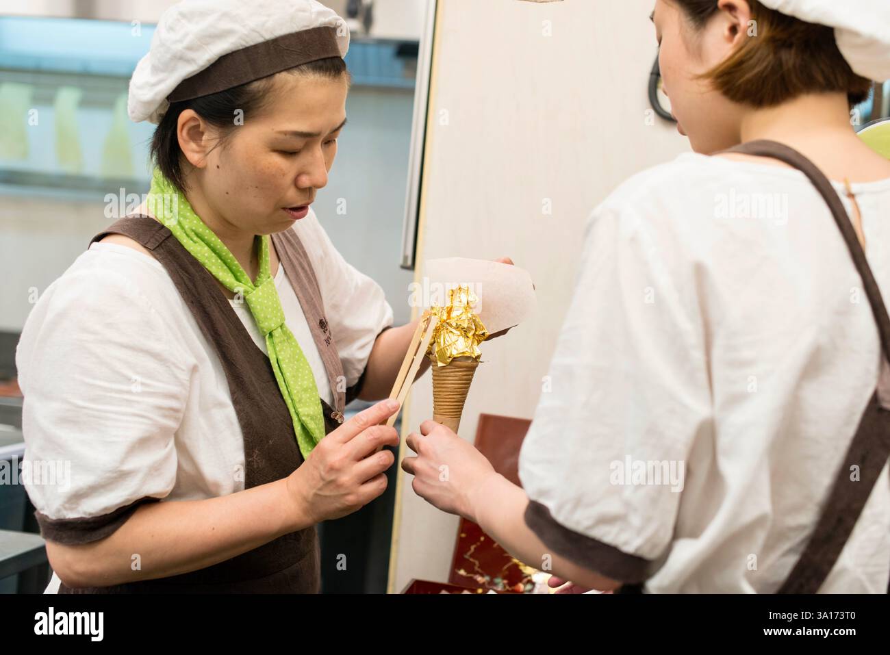 Ice cream wrapped in Kanazawa gold leaf is prepared at Ayamame Shibata, a store inside Omicho Ichiba market in Kanazawa, Ishikawa Prefecture Japan on Stock Photo