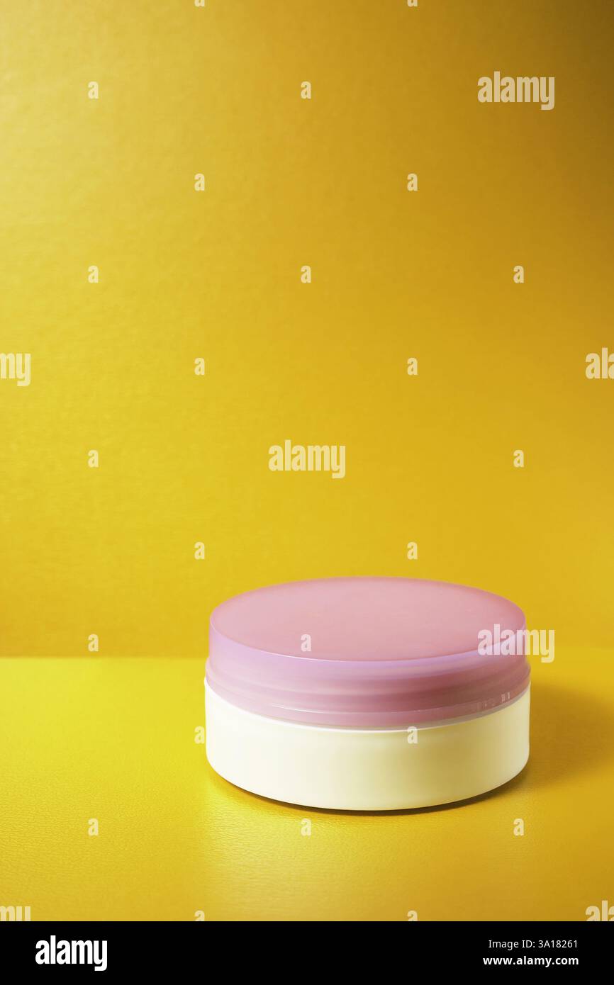 container face cream white with purple cap on yellow background. with ...