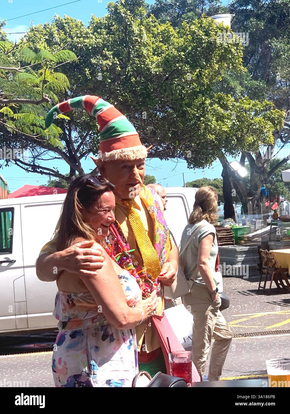 street party Carnival Clown hat lady man hot sunny weather Tenerife Canary Islands Spain coloured shirt tunic big large happy friendly street art - Smartphone Captured Stock Image