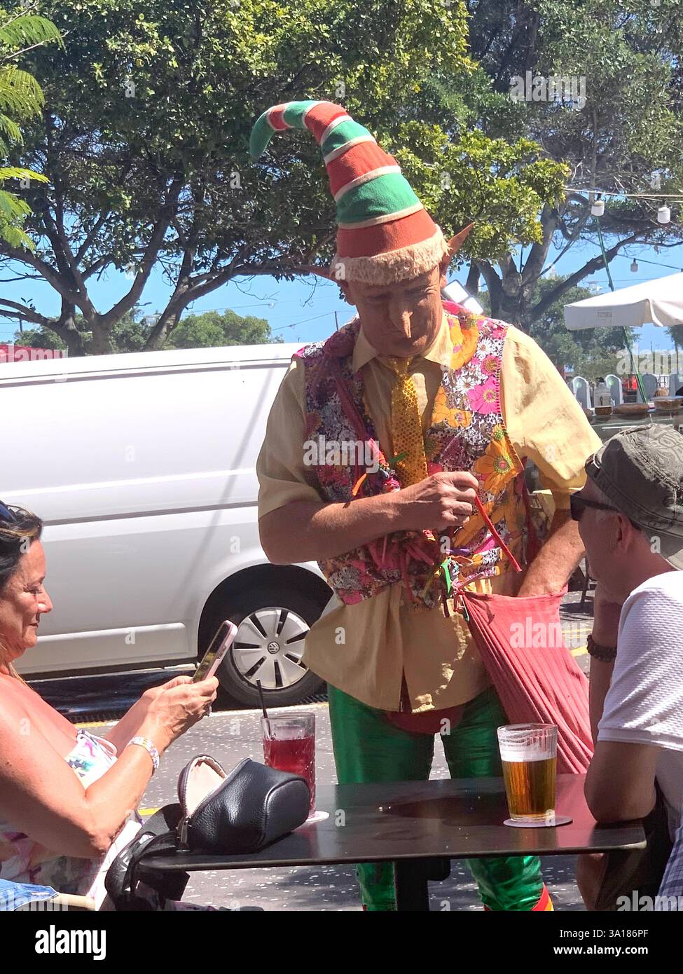 street party Carnival Clown hat lady man hot sunny weather Tenerife Canary Islands Spain coloured shirt tunic big large happy friendly street art - Smartphone Captured Stock Image