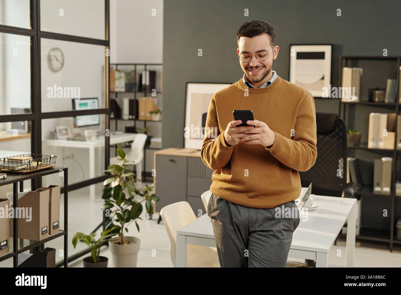 Young Man Using Phone in Office Stock Photo