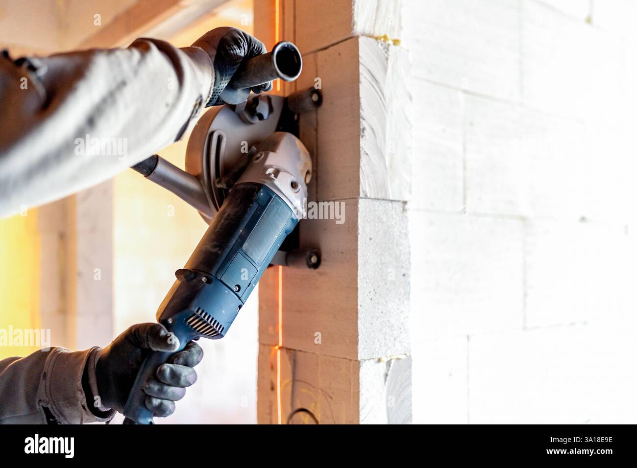 Construction worker cutting aerated concrete blocks with angle grinder ...