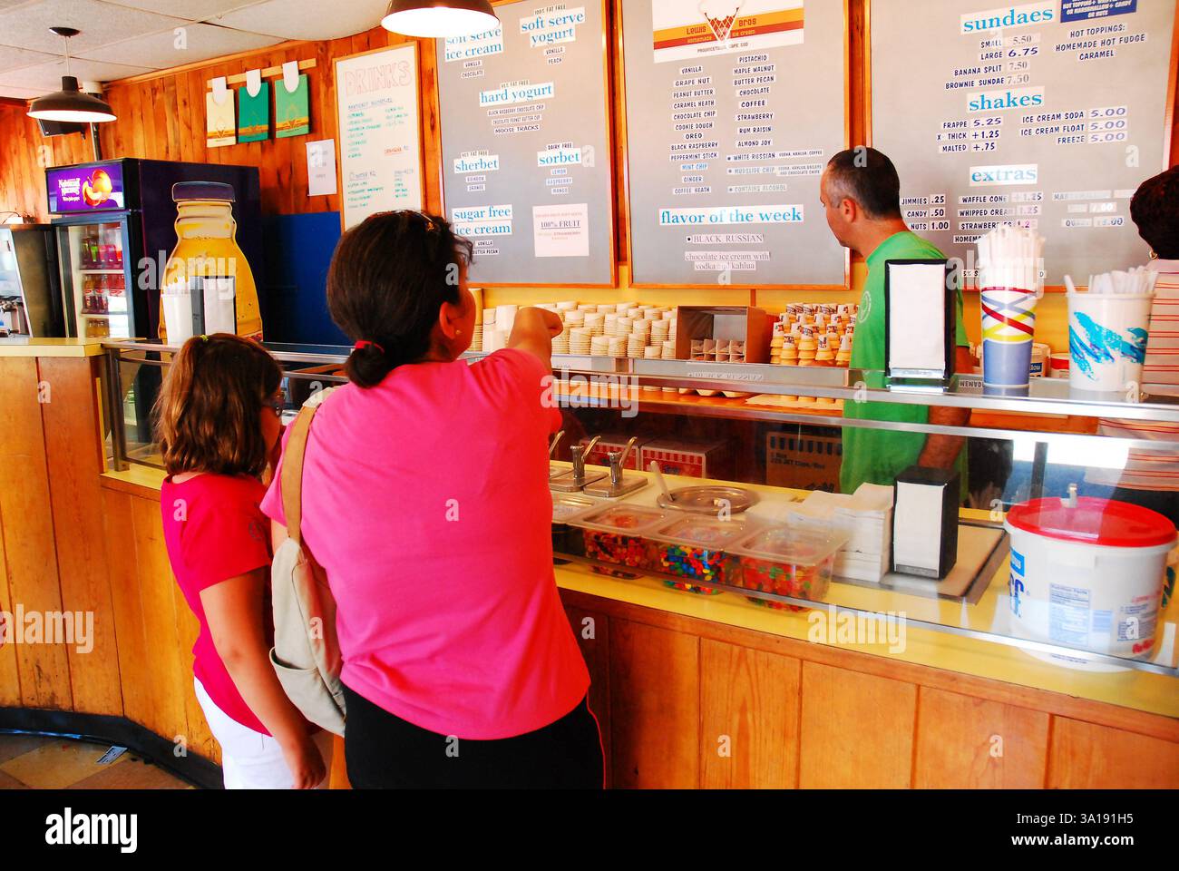 A mother and daughter chose their flavor of ice cream at a shop on a warm summer vacation day Stock Photo