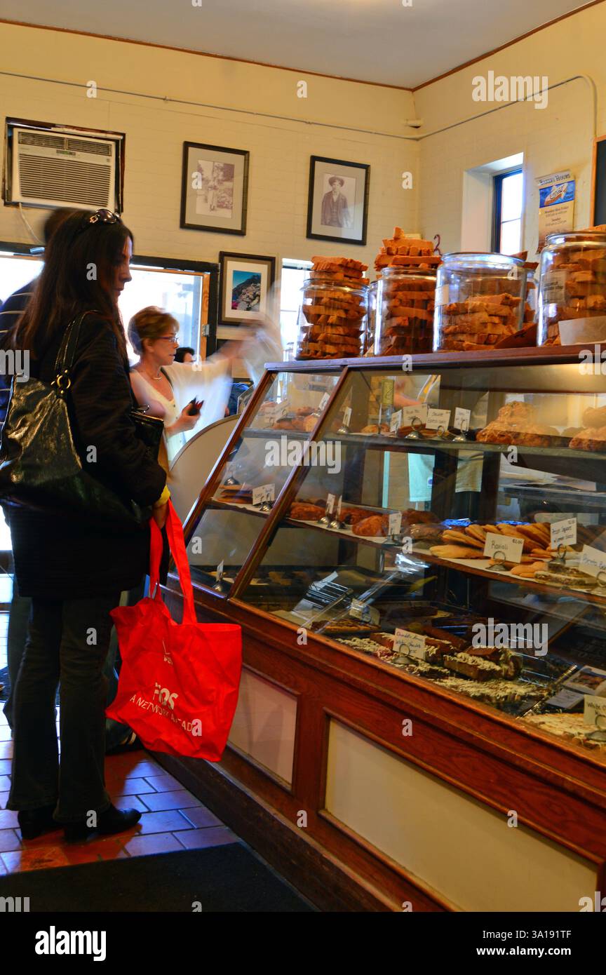 Customers browse the desserts, pastries and treats at a cafe and bakery Stock Photo