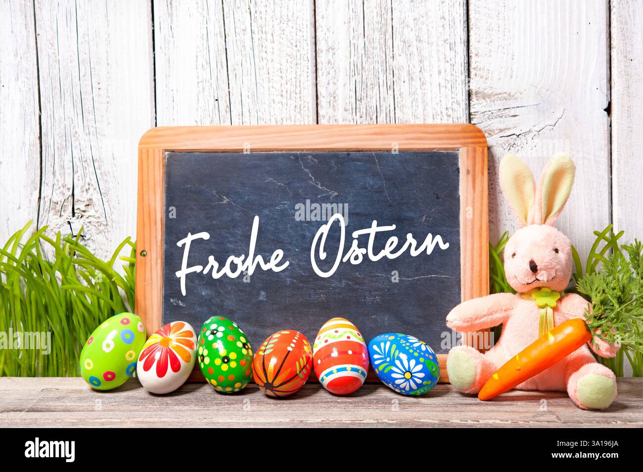 Background for Eater with german text. Easter decoration with sugar rabbit, eggs and message board Stock Photo