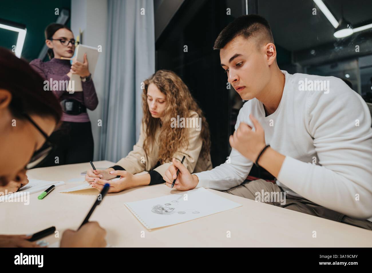 Students collaborating on creative projects in classroom setting Stock Photo