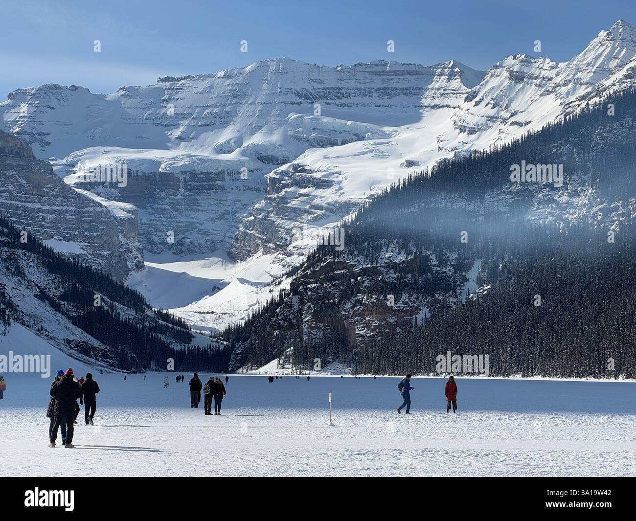Unidentified people ice skating in a frozen lake in Lake Louise in alberta, Canada - Smartphone Captured Stock Image