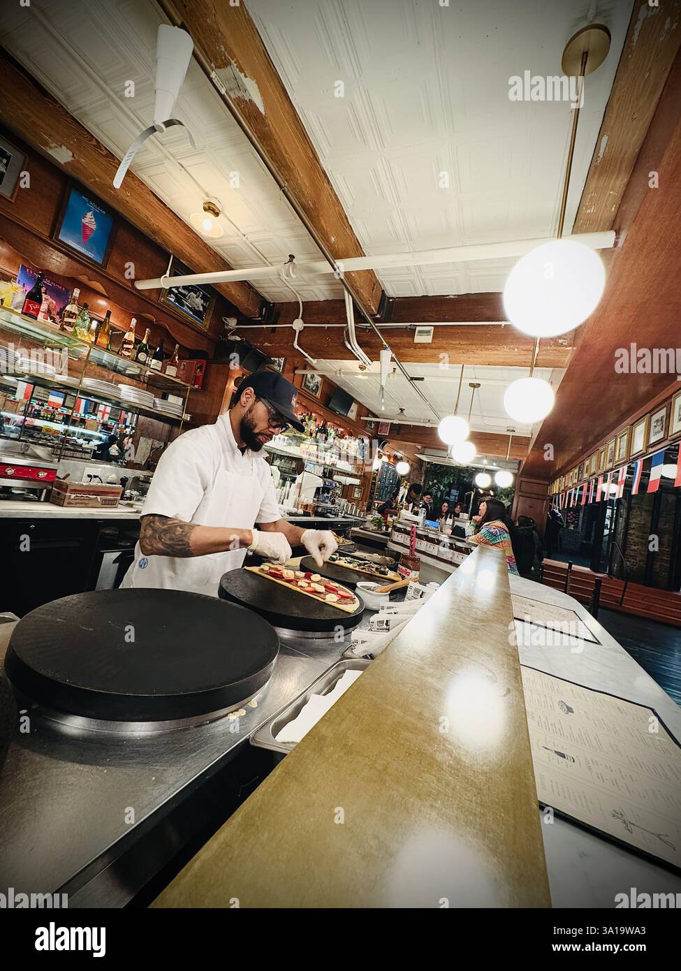 Unidentified man doing pancakes in the Chelsea Market in New York City, NY - Smartphone Captured Stock Image