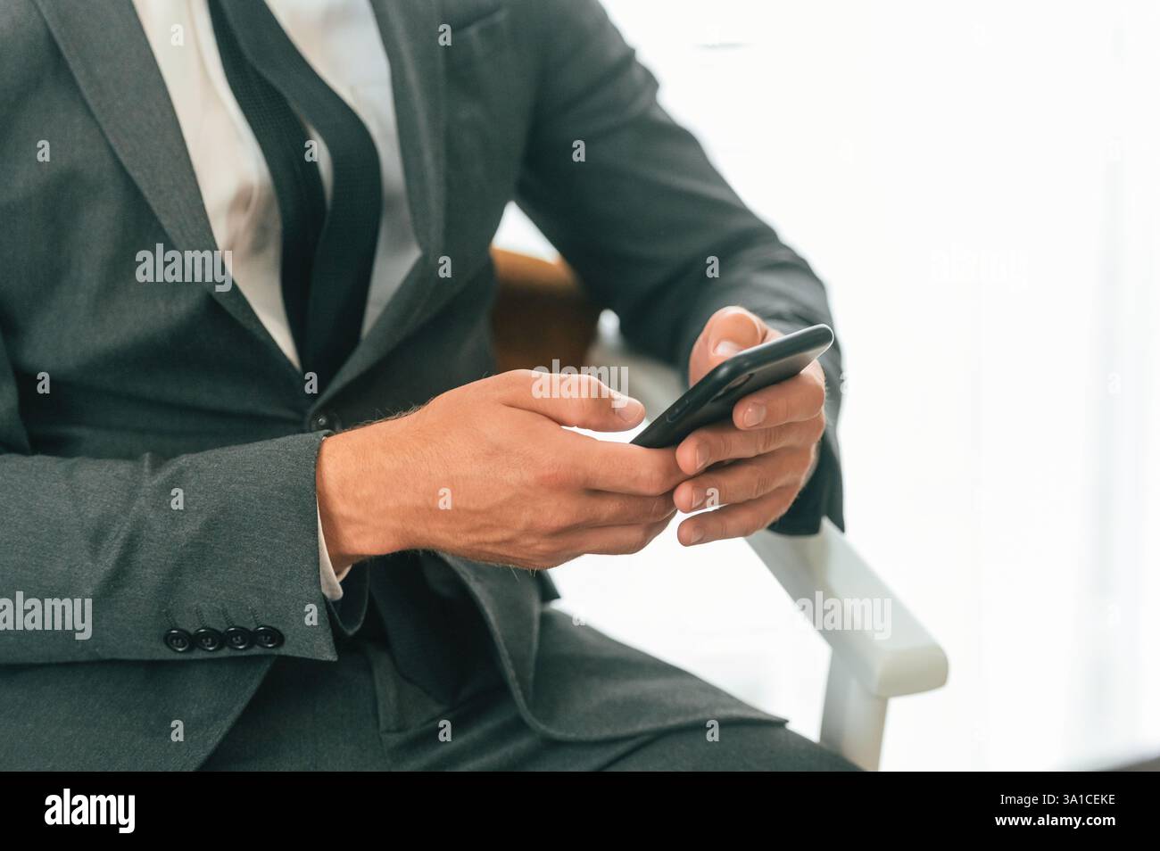 Close up view of businessman that is sitting and using smartphone. Stock Photo
