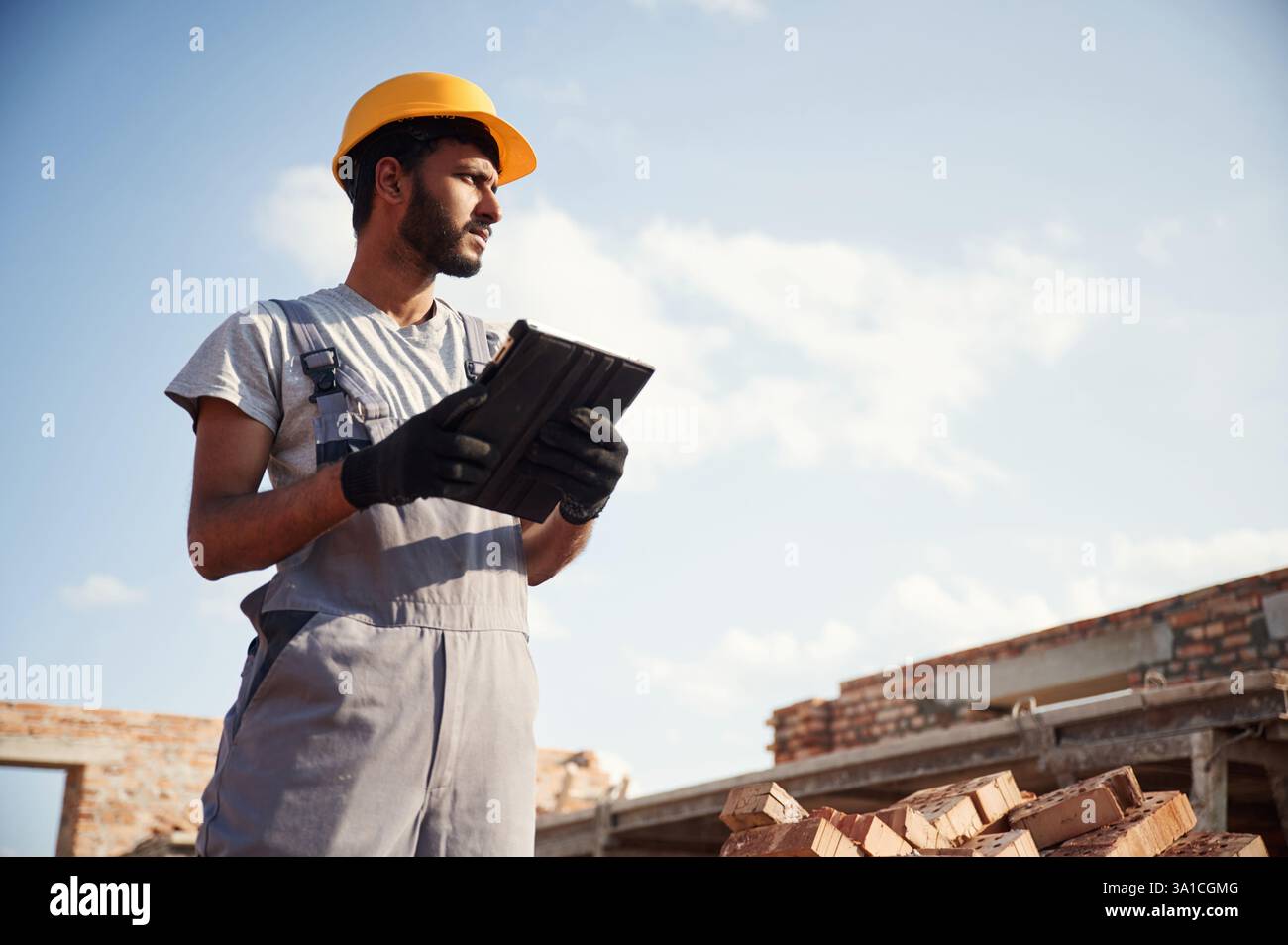 Manager with digital tablet. Handsome Indian man is on the construction site. Stock Photo