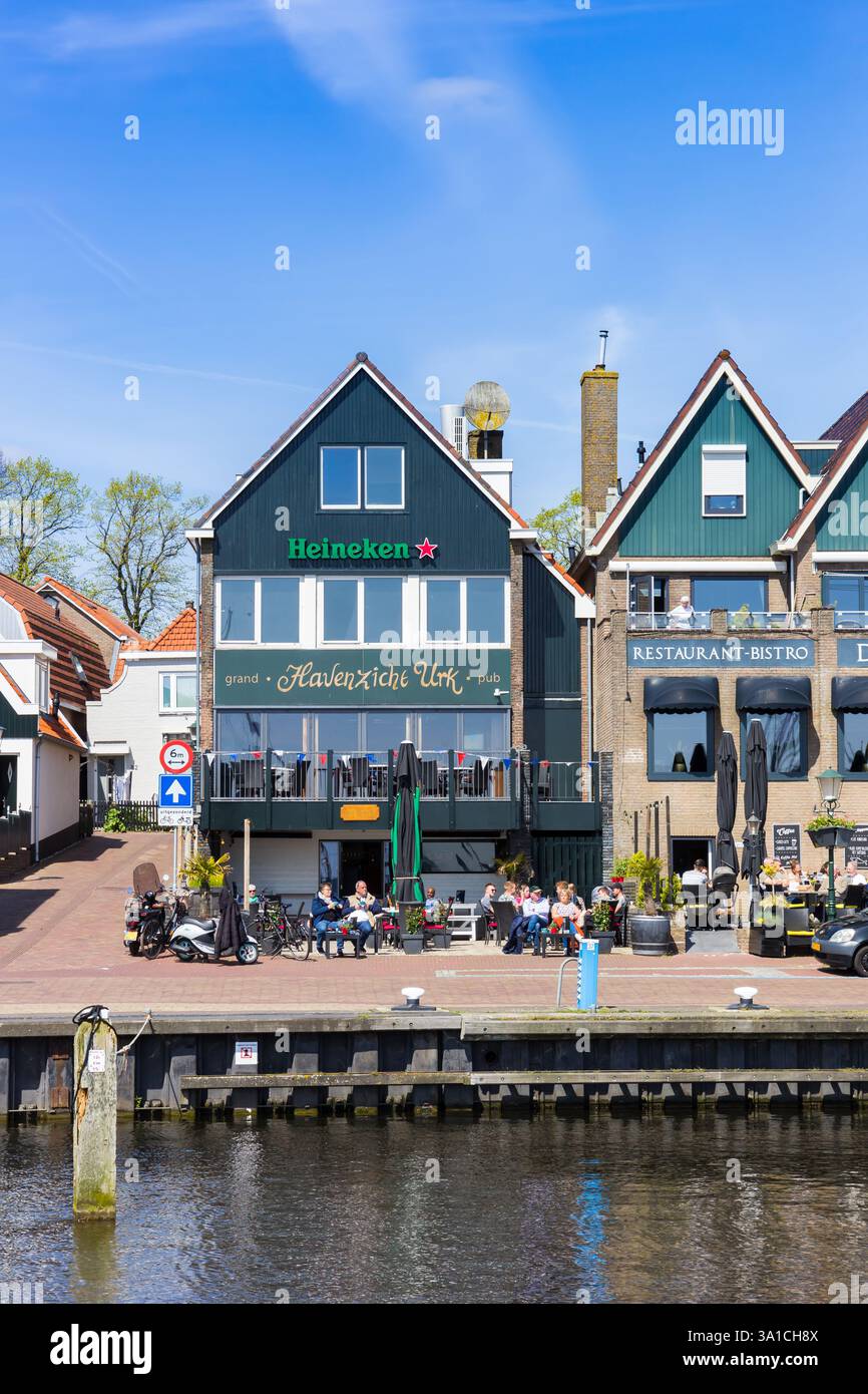 People enjoying the spring sun at a cafe in the harbor of Urk, Netherlands Stock Photo