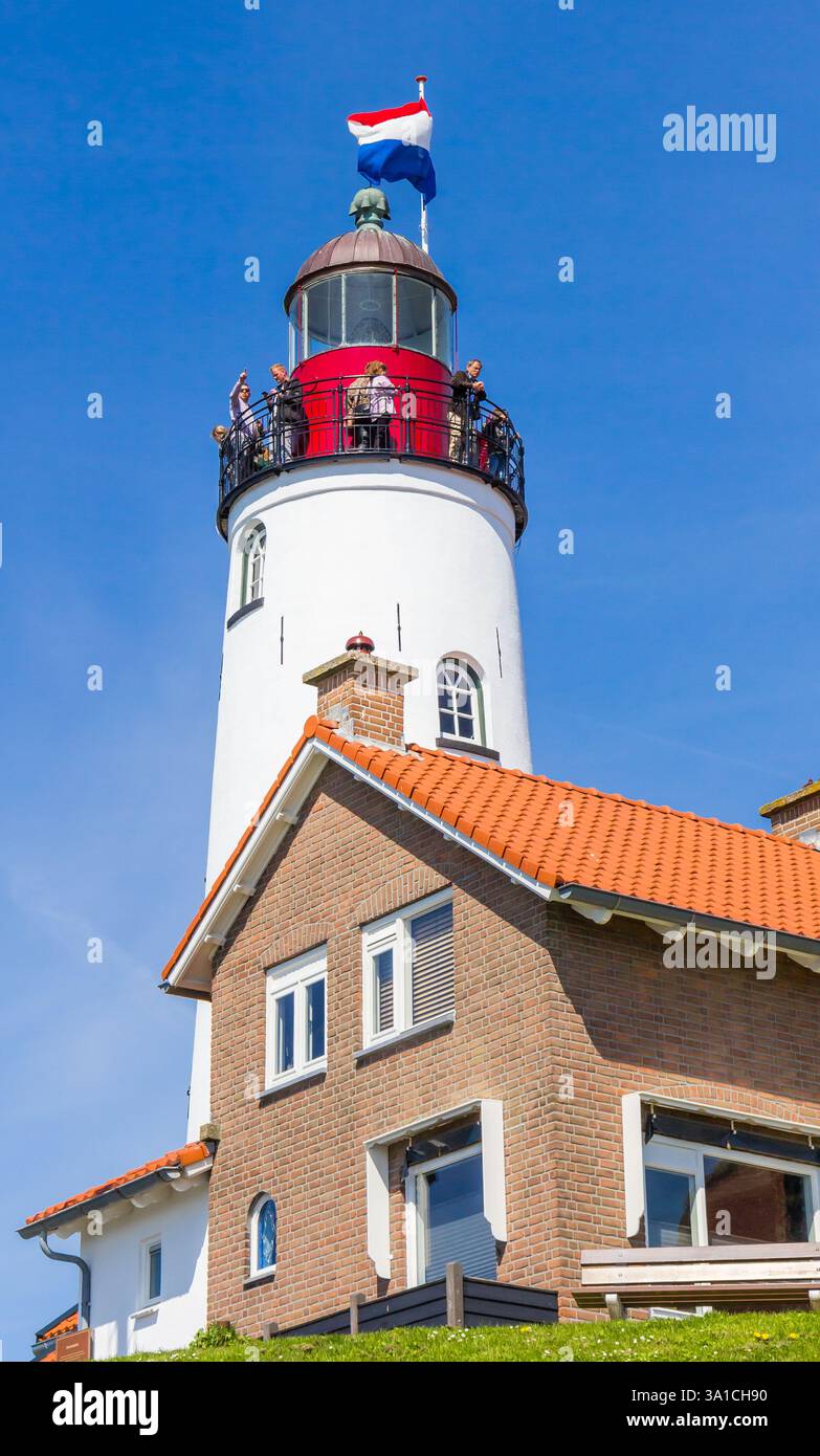 Historic lighthouse with people enjoying the view over the sea in Urk, Netherlands Stock Photo