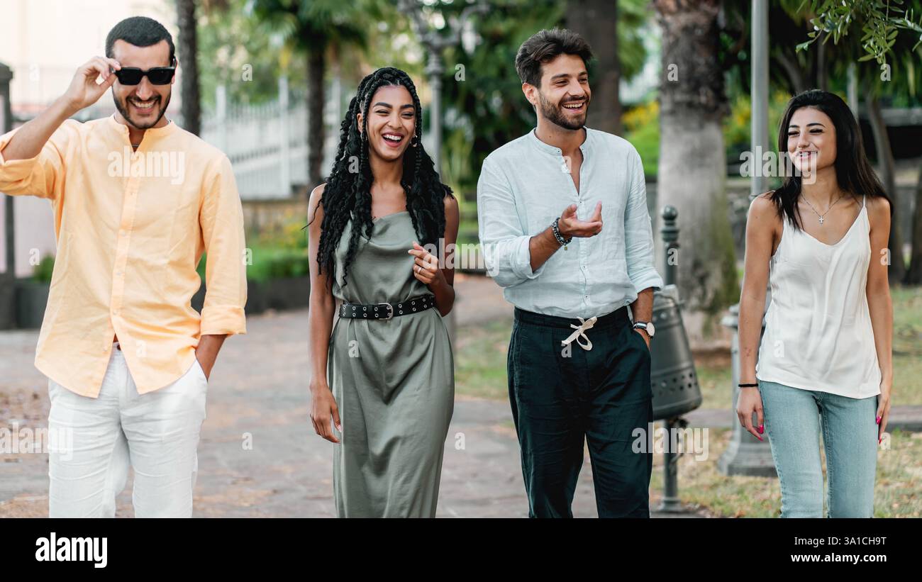 A group of young diverse friends walking and laughing together in an ...