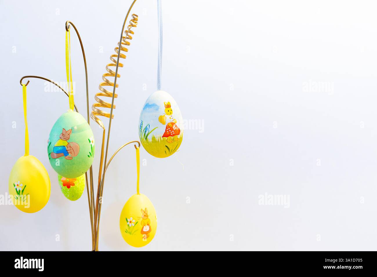 Easter hanging decorations with colorful painted Easter eggs against white background, Easter home decor. Stock Photo