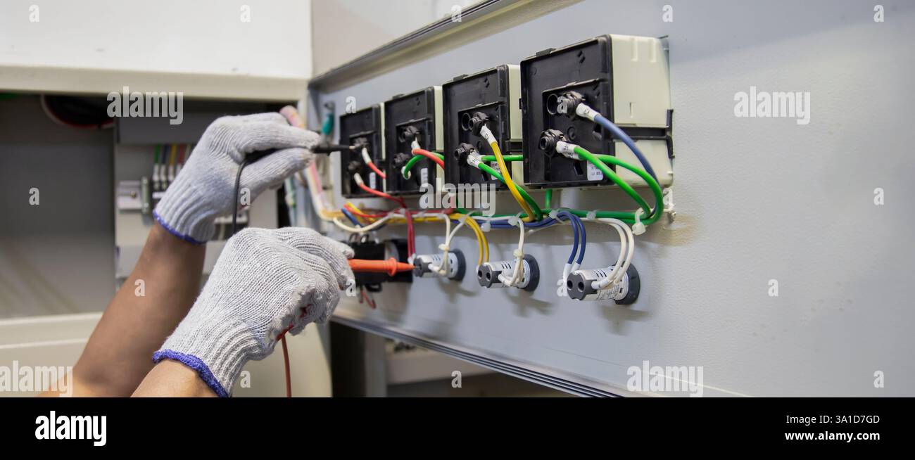 Technicians use multimeter to test or diagnose electrical control devices. Stock Photo