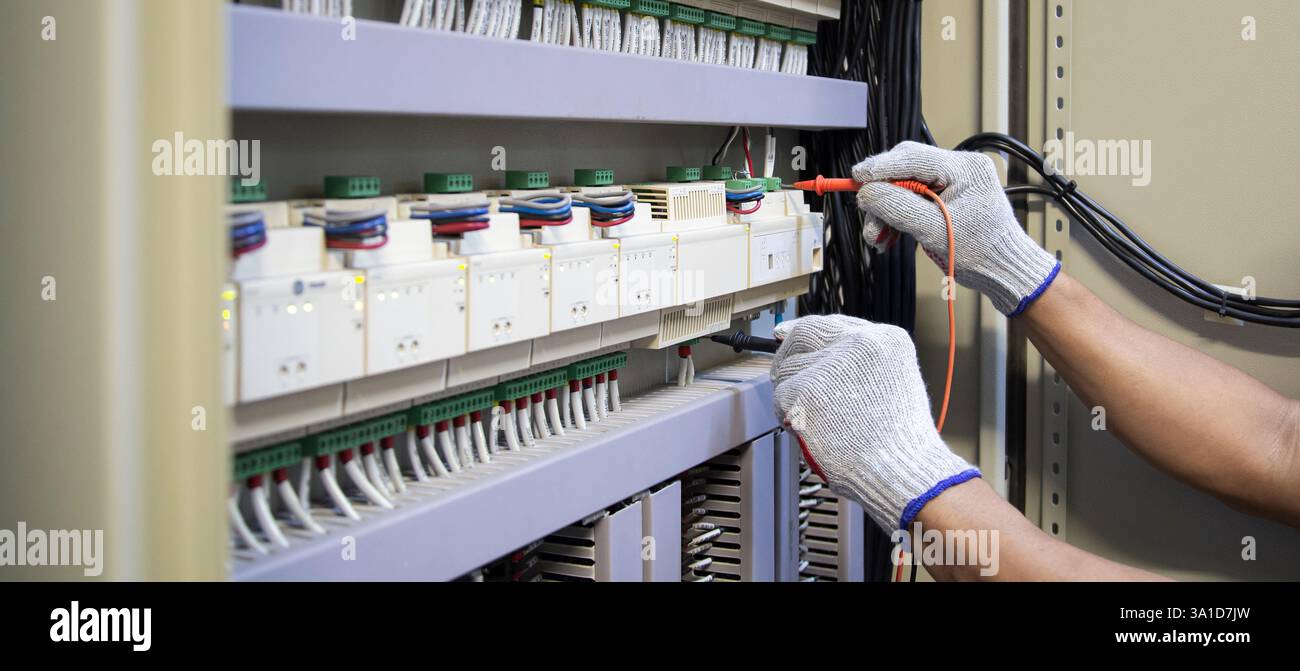 Technicians use multimeter to test or diagnose electrical control devices. Stock Photo
