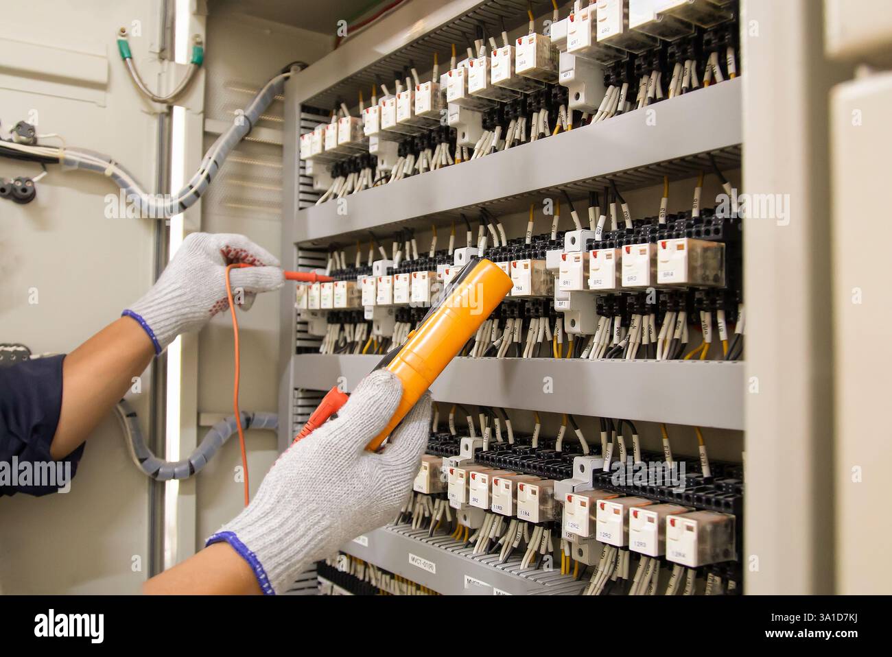 Technicians use multimeter to test or diagnose electrical control devices. Stock Photo