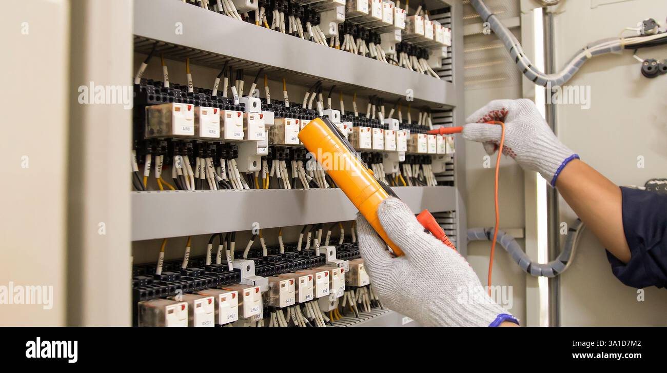 Technicians use multimeter to test or diagnose electrical control devices. Stock Photo