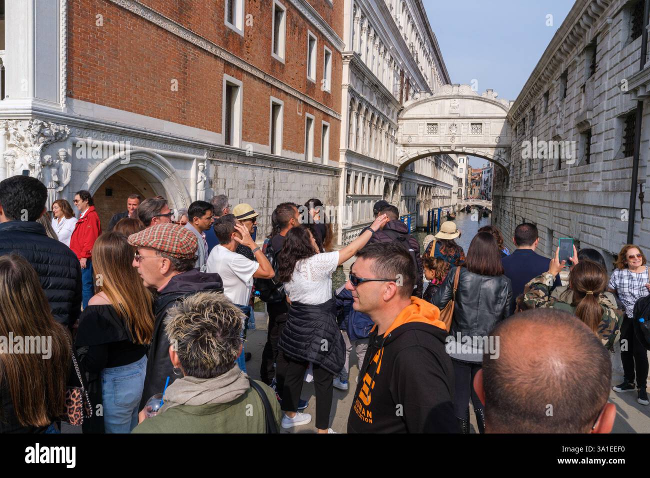 Venice, Italy - 12 October 2024: Tourists gather on a bridge overlooking the Bridge of Sighs, illustrating the impact of overtourism in Venice Stock Photo
