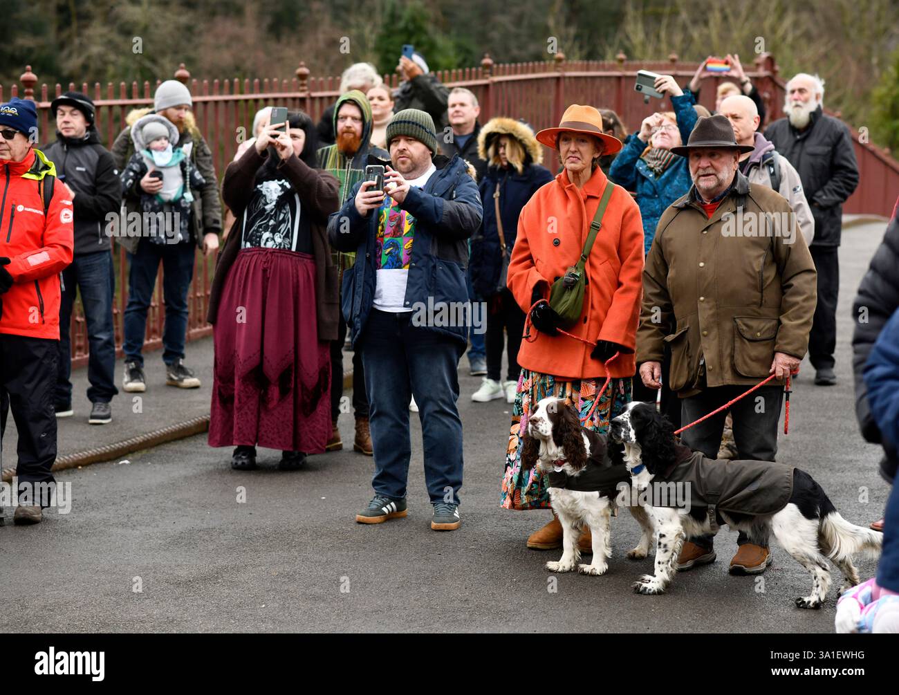People visitors tourists watching the  New Years Day dancers brighten up a dull  day on the famous Ironbridge. The Ironmen and Severn Gilders  Morris Stock Photo