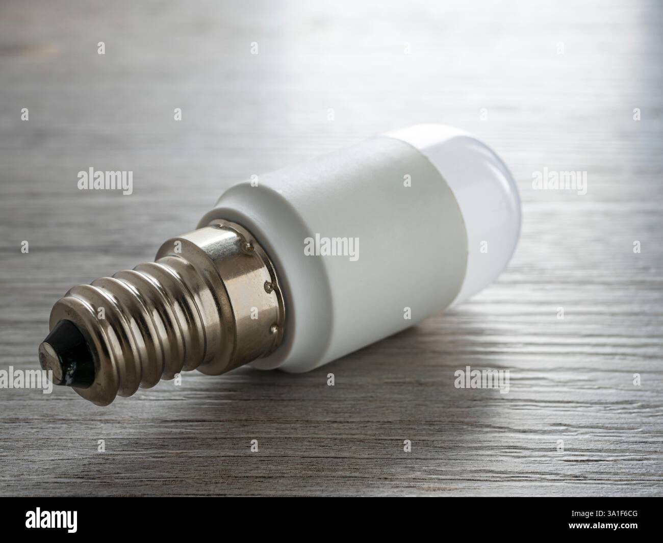 LED light bulb on wooden surface. Close up. Stock Photo