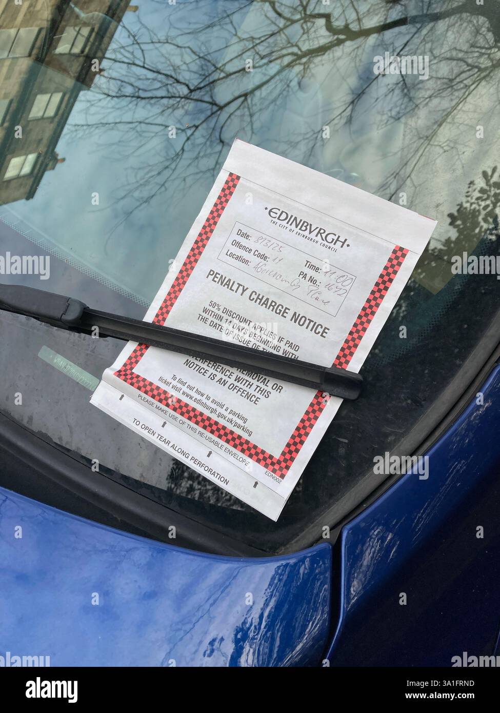 Parking ticket - Penalty charge notice, on car windscreen, issued by Edinburgh traffic warden - Smartphone Captured Stock Image