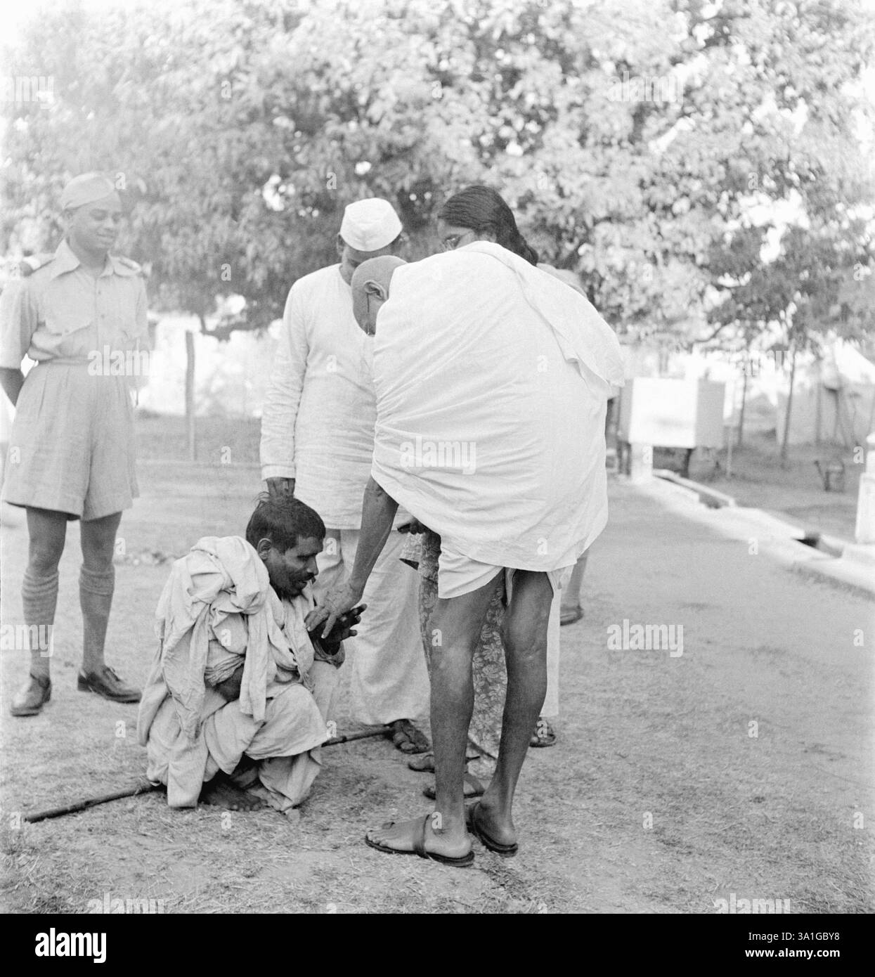 Mahatma Gandhi, greeting a blind man during his visit to the riot ...
