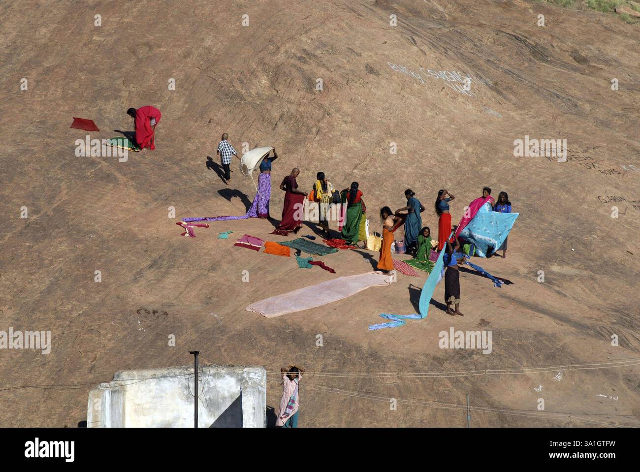 Women drying clothes on rock Tirupparankundram temple hill, Tamil Nadu ...