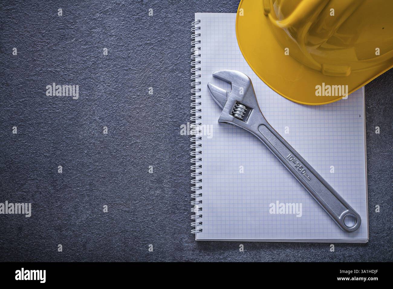 Notebook hard hat adjustable wrench construction concept Stock Photo