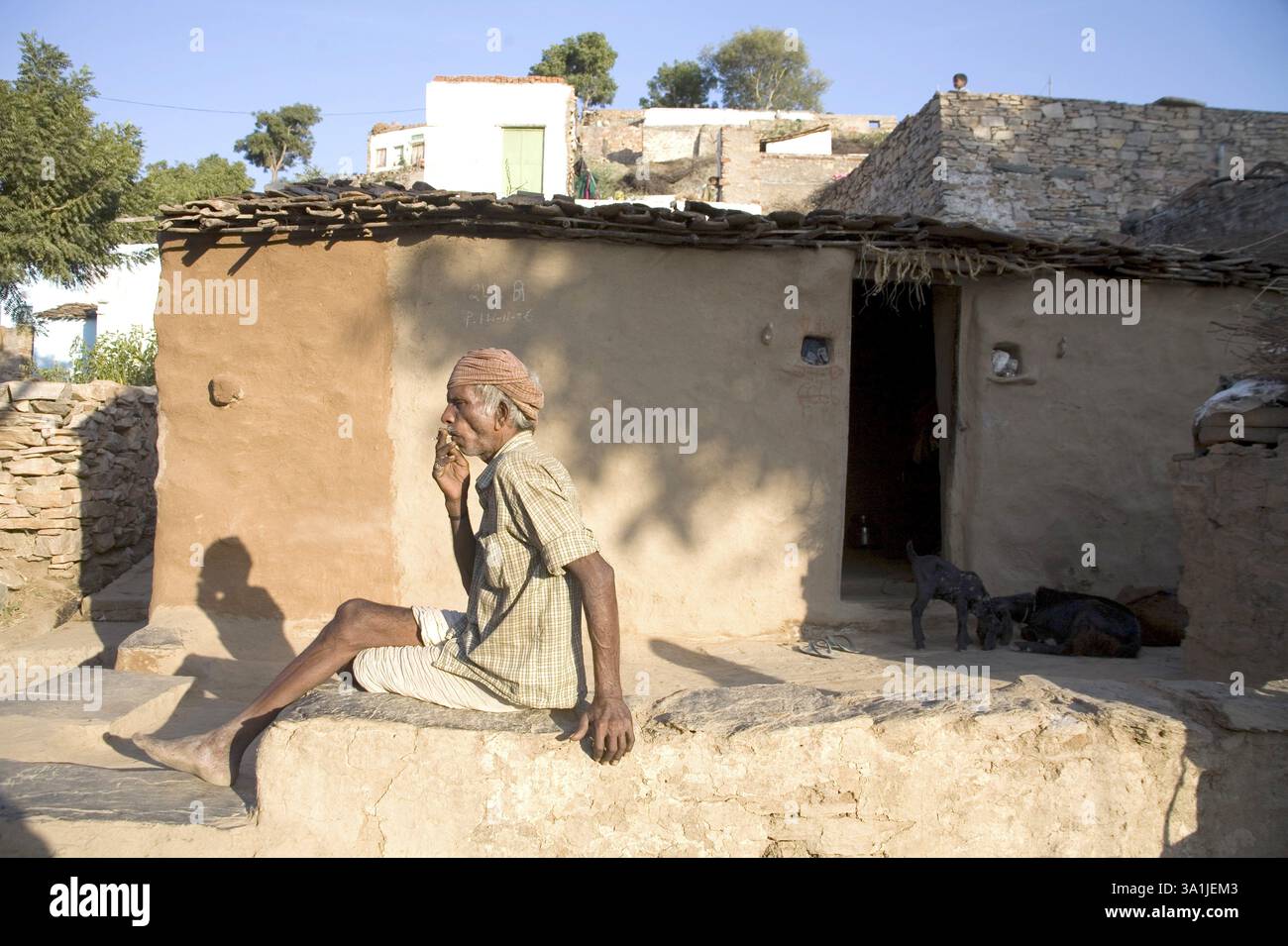 Rural man male of Bheel community relaxing outside his hut, semi urban ...