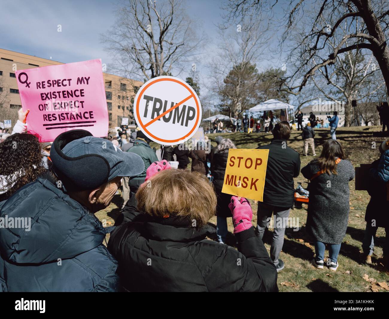 Protesters holding anti-Trump, Stop Musk, and other signs at the International Women's Day rally in Flint Michigan USA, March 8 2025 - Smartphone Captured Stock Image