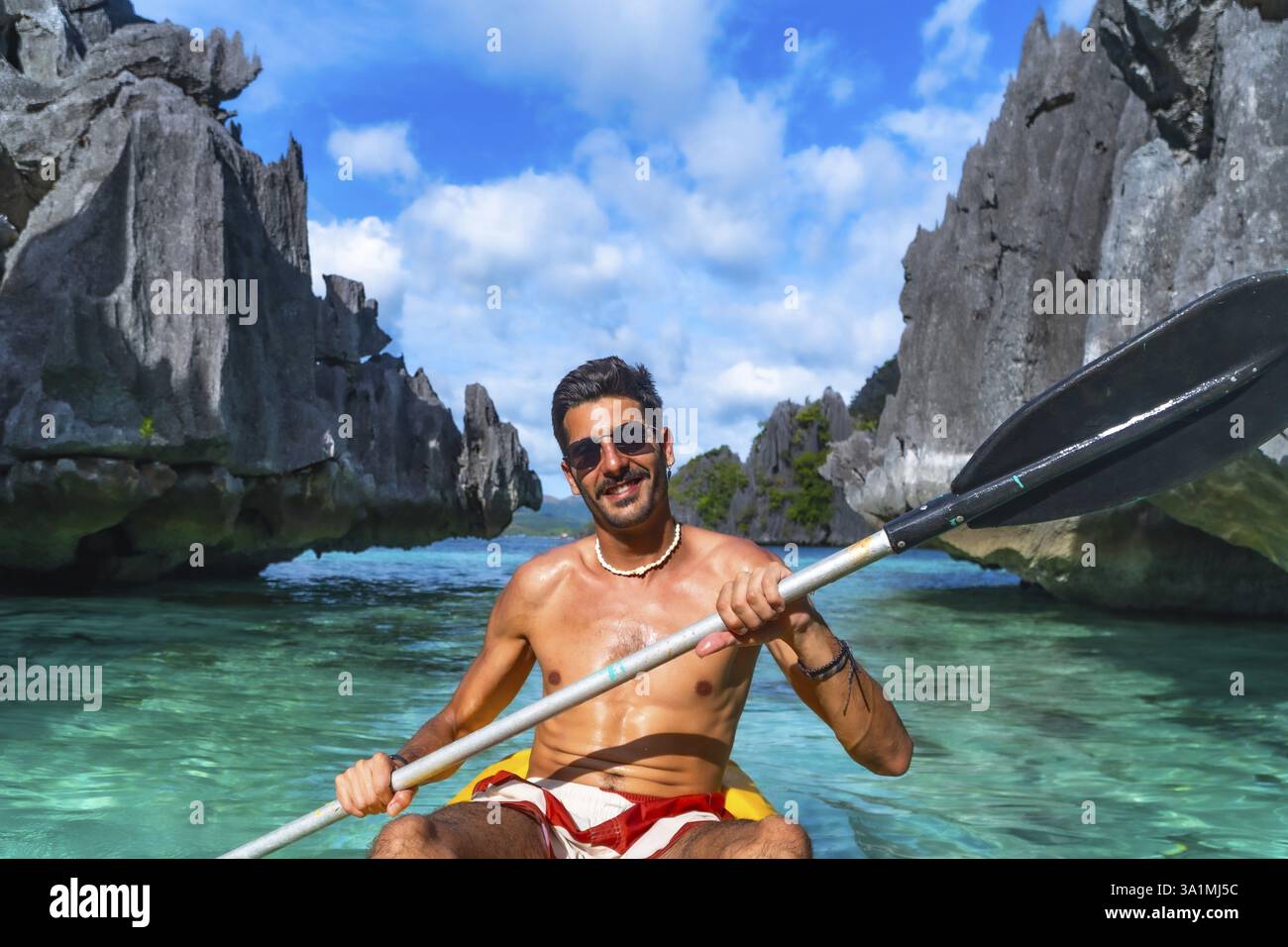 Tourist enjoys kayaking in the crystal clear waters of twin lagoon ...