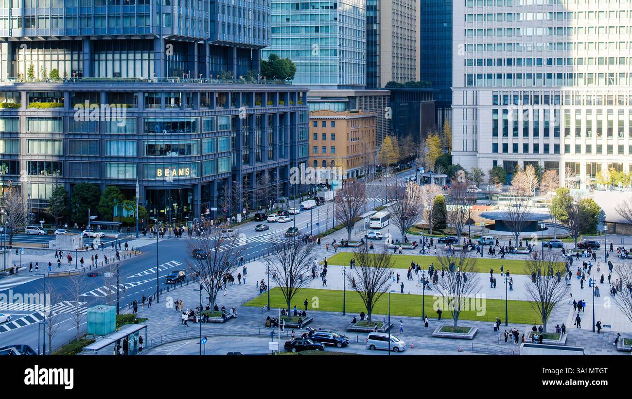 A cluster of modern office buildings in Tokyo, Japan, featuring sleek glass facades, geometric architectural patterns, and reflective surfaces. The mi Stock Photo
