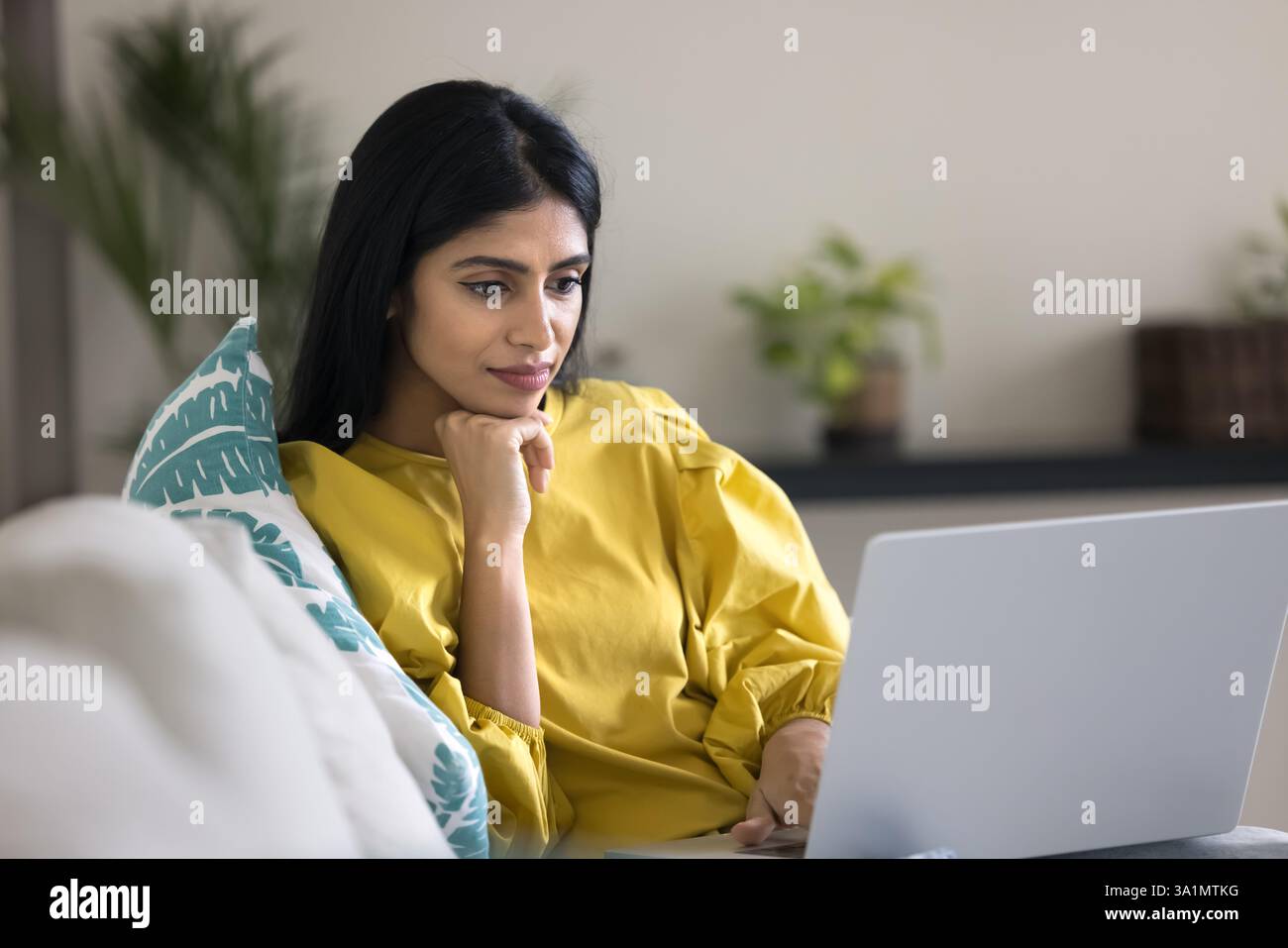 Indian woman watching educational or informative content on laptop Stock Photo