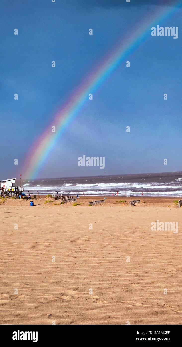 Villa Gesell, 16.02.2025: A rainbow forms in the late afternoon on the beach of Atlantic coast of the province of Buenos Aires (Néstor J. Beremblum) - Smartphone Captured Stock Image