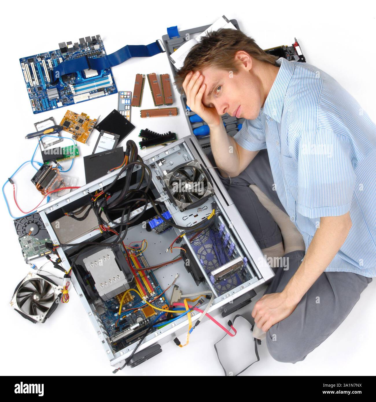 Frustration while trying to assemble computer hardware. Man has problems with technology and electronics Stock Photo