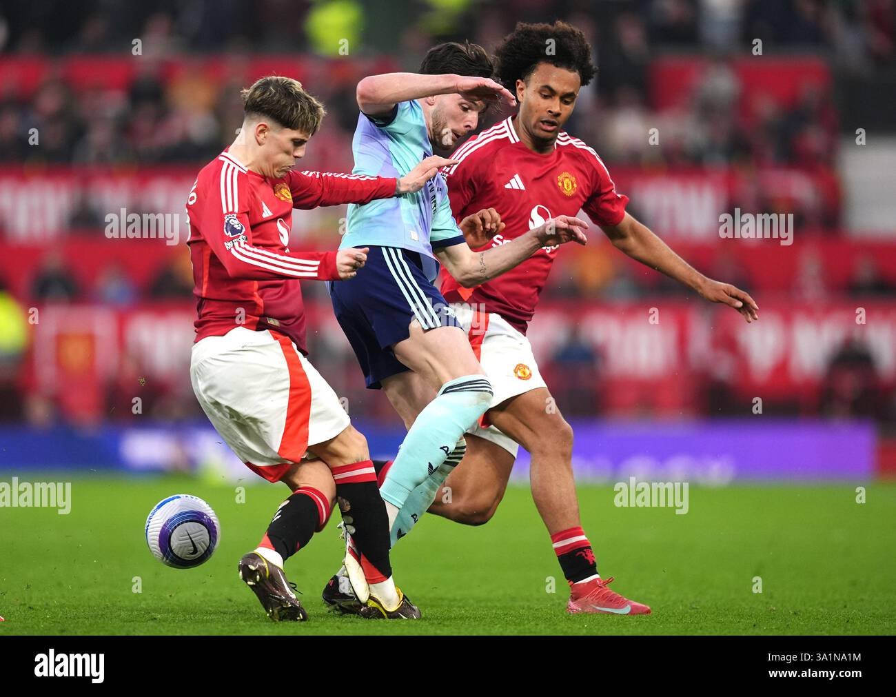 Arsenal's Declan Rice (centre) battles for the ball with Manchester ...