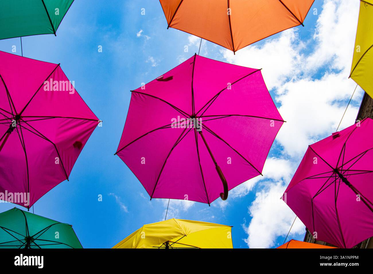 Multicolored umbrellas against a blue sky Stock Photo