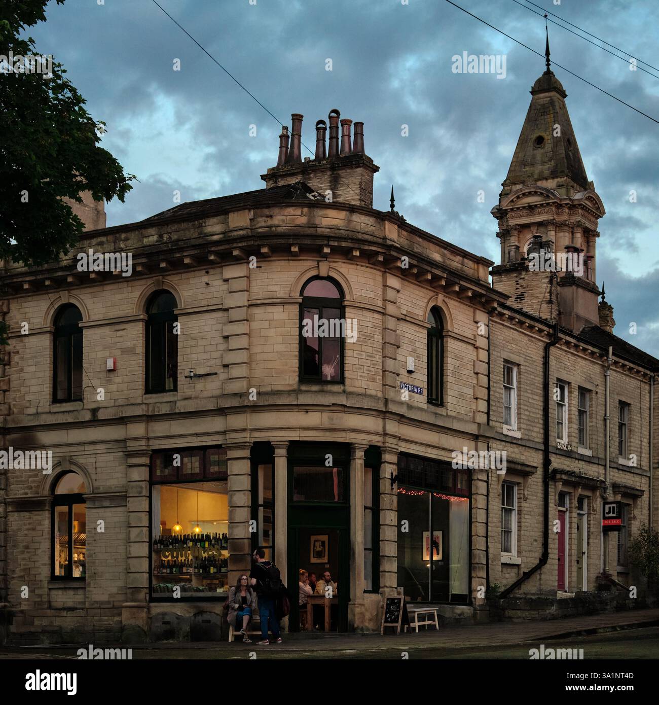 Exterior of Cultures Deli and Draughthouse in Saltaire Model Village in Shipley, Bradford serving beer, wine and cheese at dusk Stock Photo