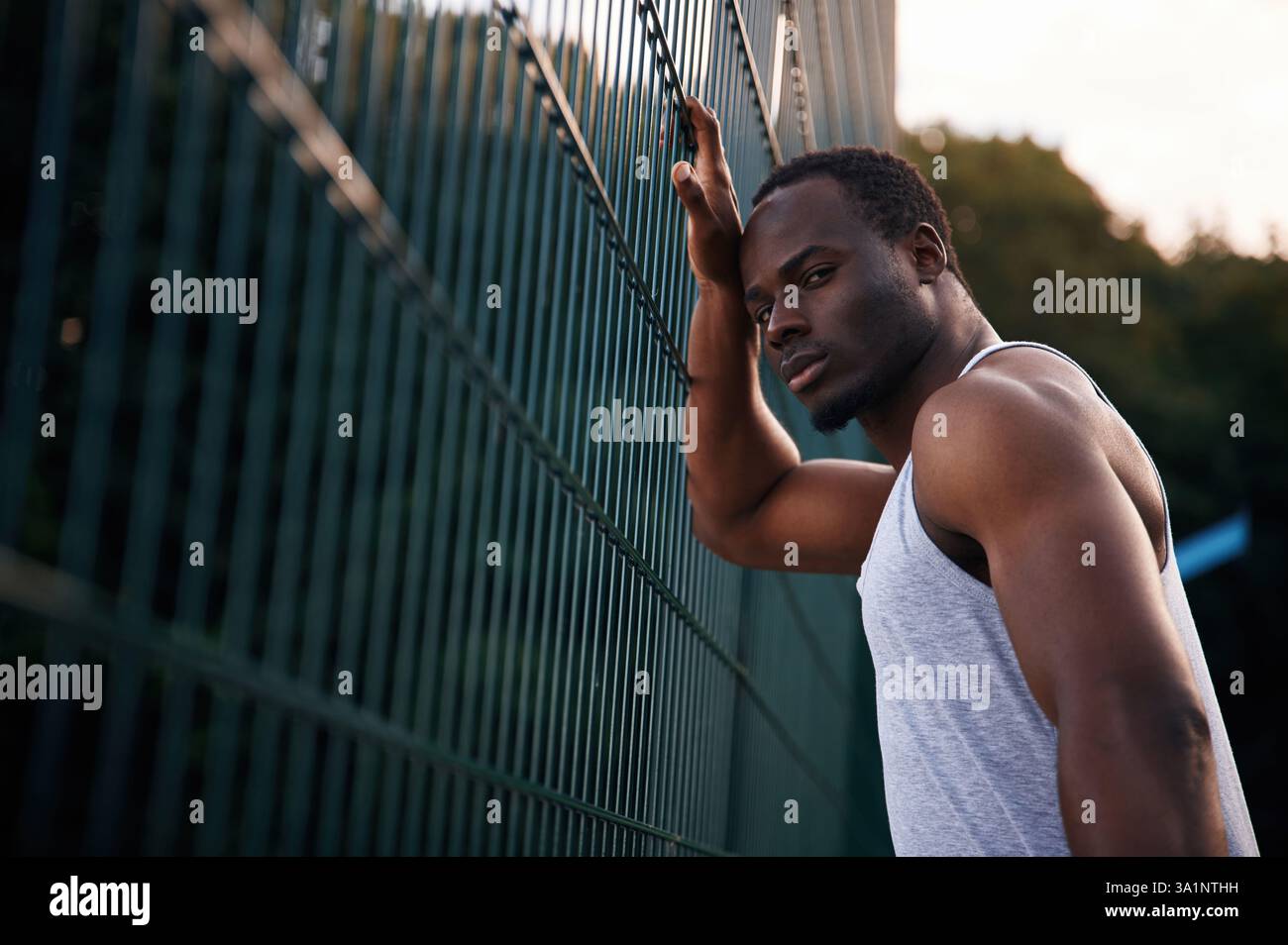 Posing and standing. Handsome black man is posing outdoors at daytime. Stock Photo